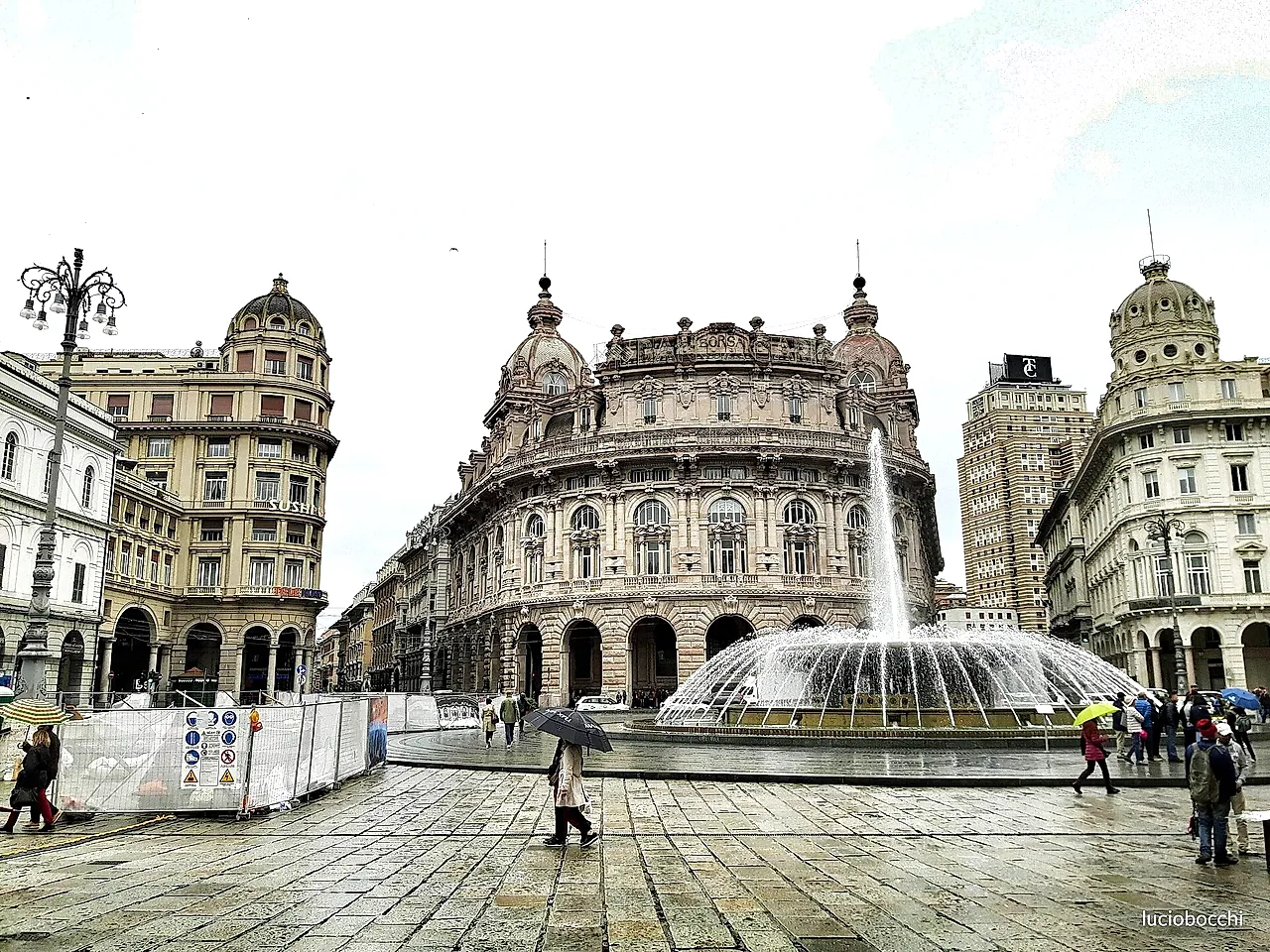 Piazza De Ferrari in Genoa: the large fountain in front of the grand palaces on a rainy day